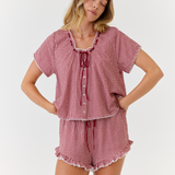 Woman wearing a red and white checkered pajama set on a white background