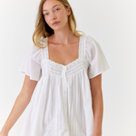 White cotton mini dress worn on a sunny summer morning