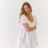 Model wearing lightweight white mini dress styled for summer